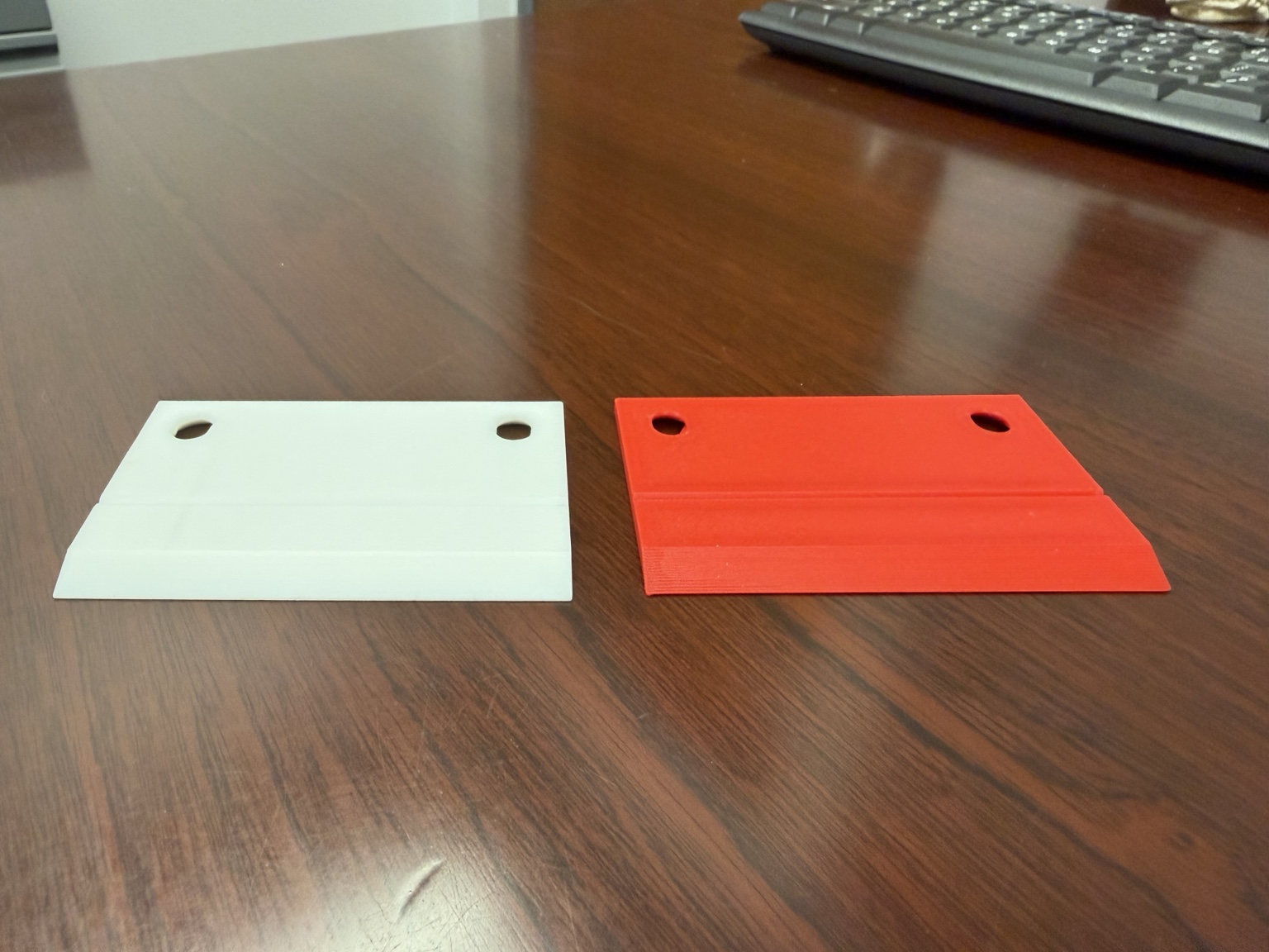 White original OEM machine guide beside the red reverse-engineered printed replacement